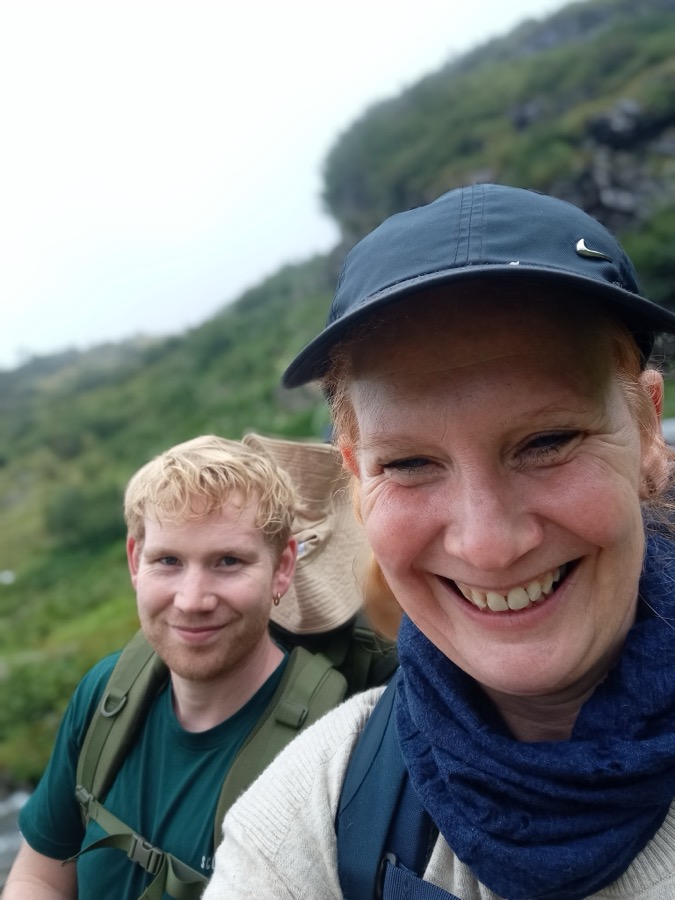 Zwei Personen auf einer Wanderung in den Bergen lächeln in die Kamera