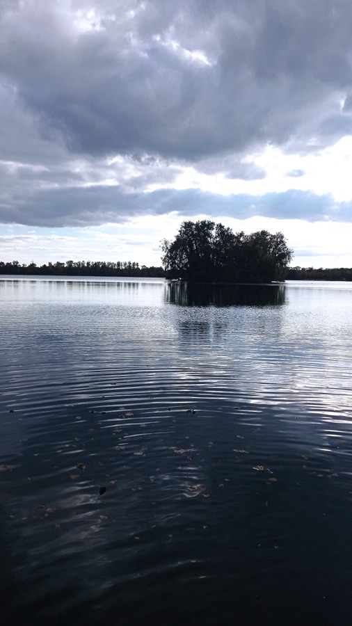 Insel im See, grauer Himmel